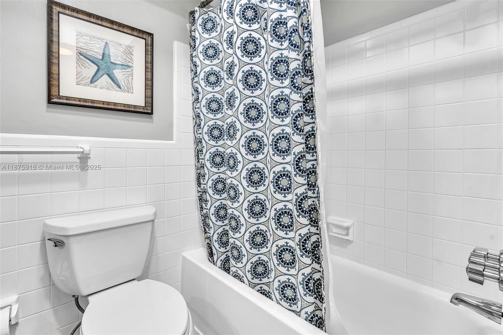 2501 North Ocean Boulevard, Unit 18 Pompano Beach, FL 33062 - Photo 27 of 36 a bathroom with a toilet and a shower curtain