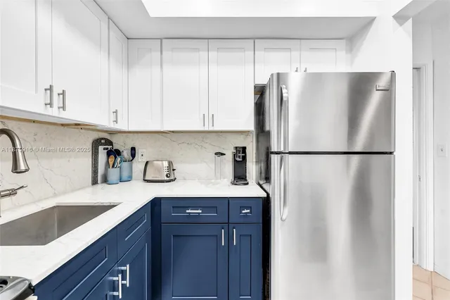 a kitchen with stainless steel appliances granite countertop a refrigerator and a sink