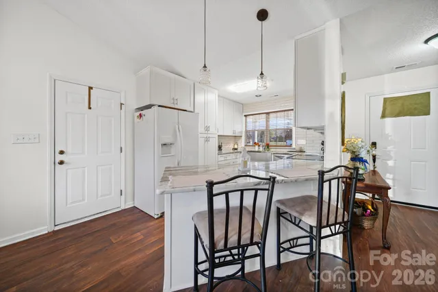 a kitchen with a sink white cabinets and white appliances