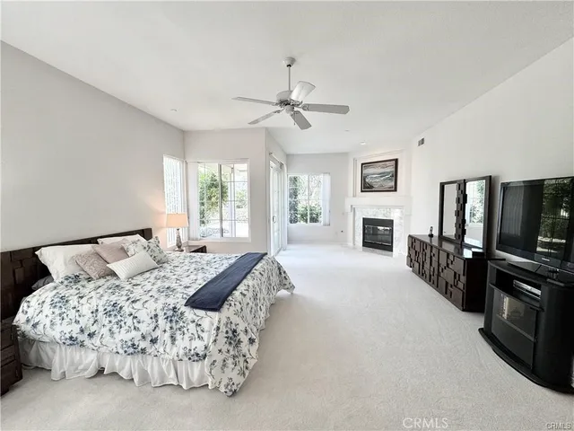 a bedroom with a bed flat screen tv and a large window