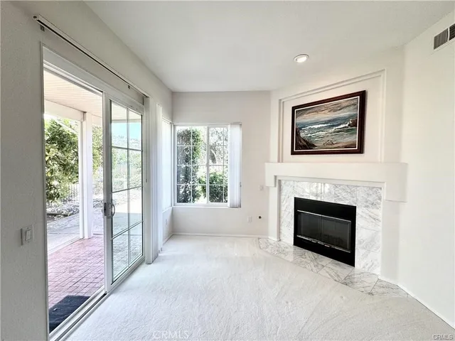 a view of a livingroom with an empty space and a fireplace