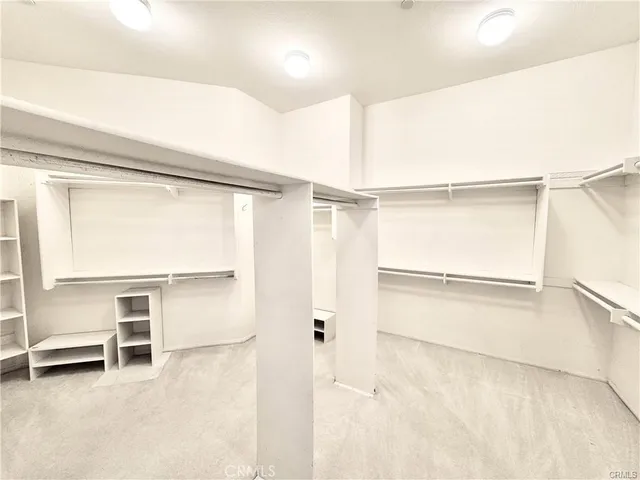 a view of walk in closet with empty racks