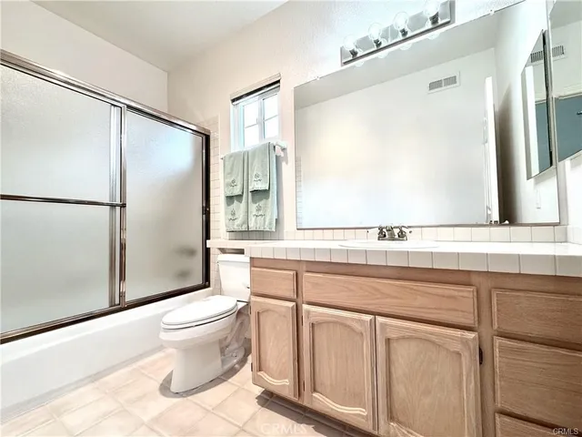 a bathroom with a sink a toilet and a large mirror
