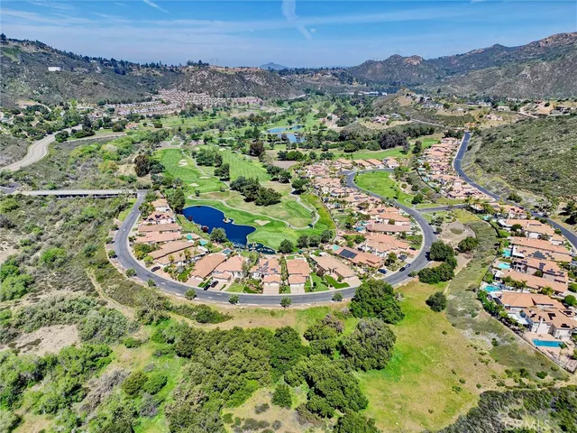 an aerial view of a houses with a lush green hillside