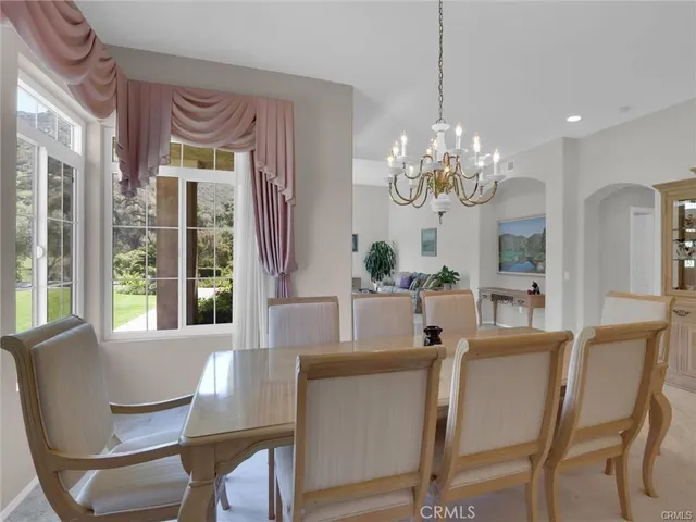 a dining room with furniture a chandelier and window
