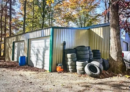 a view of a backyard with wooden fence and a large tree
