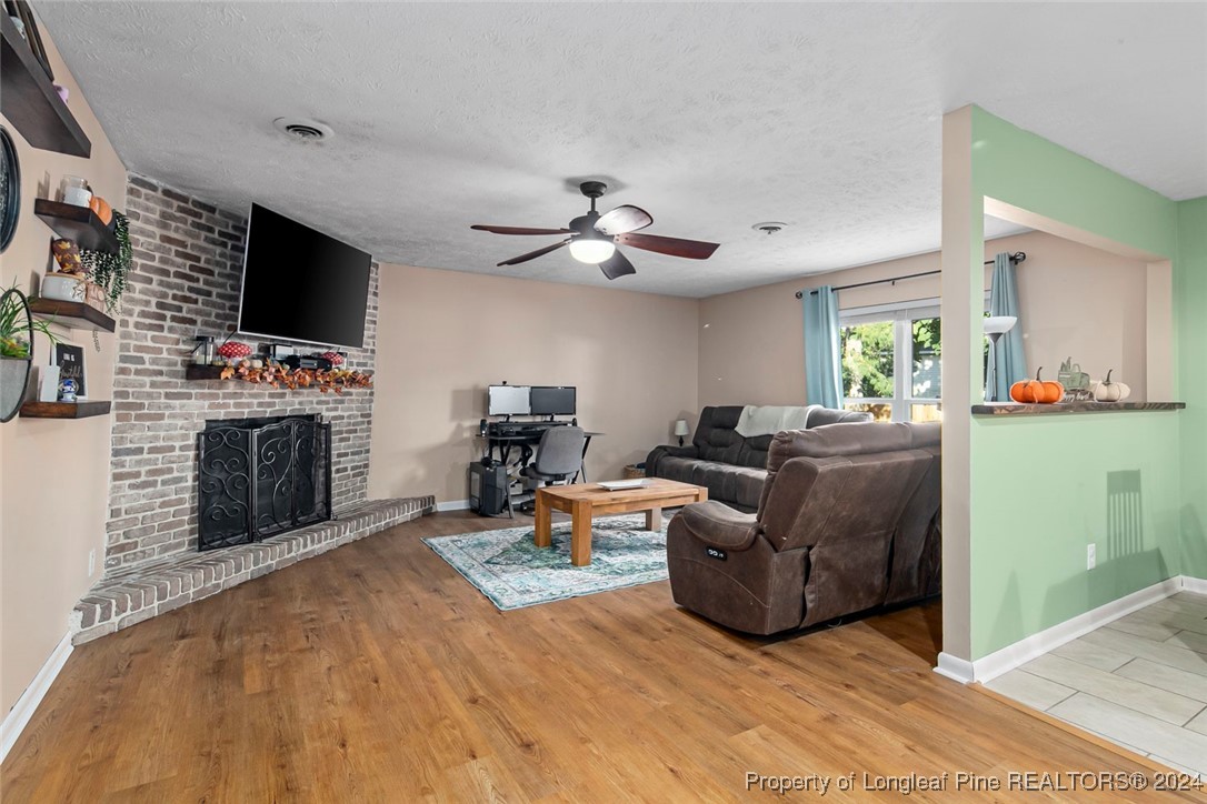 3009 Rouse Road Fayetteville, NC 28306 - Photo 16 of 37 a living room with furniture a flat screen tv and a fireplace
