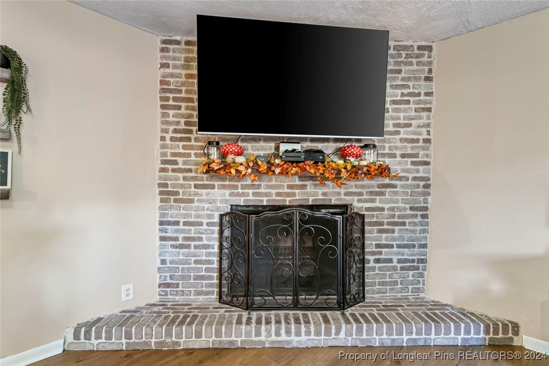 3009 Rouse Road Fayetteville, NC 28306 - Photo 17 of 37 a living room with a fireplace and a flat screen tv