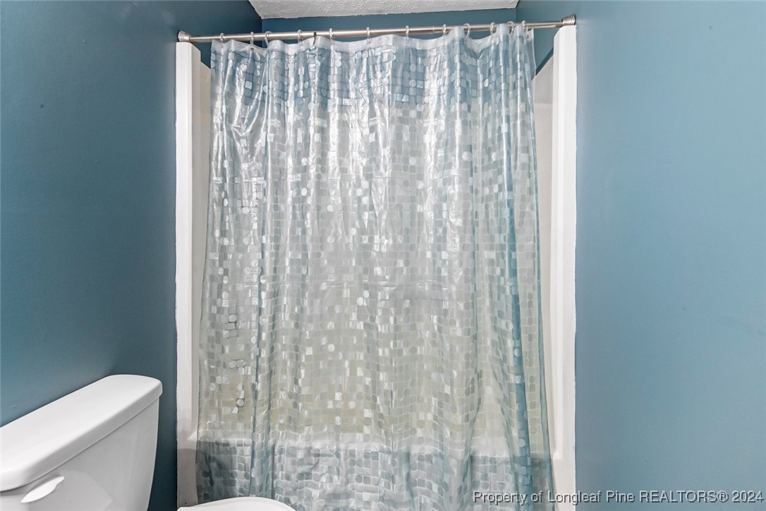 3009 Rouse Road Fayetteville, NC 28306 - Photo 25 of 37 a bathroom with a shower curtain and toilet