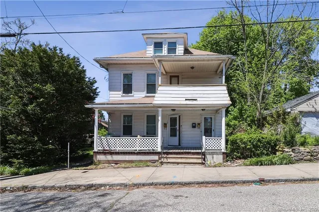 a front view of a house with a garden and plants