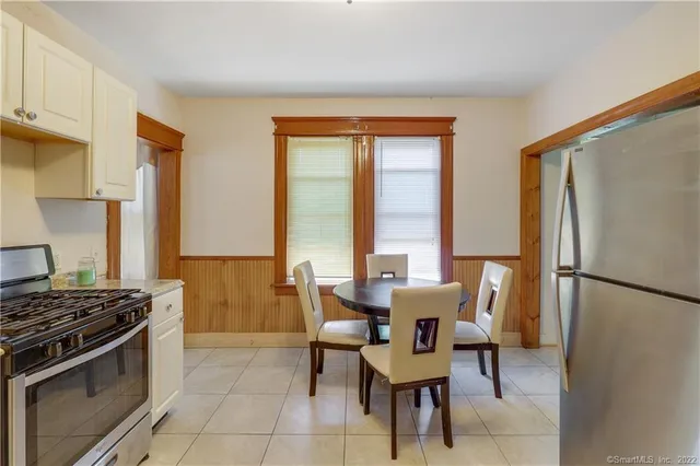 a dining room with stainless steel appliances a refrigerator and a table