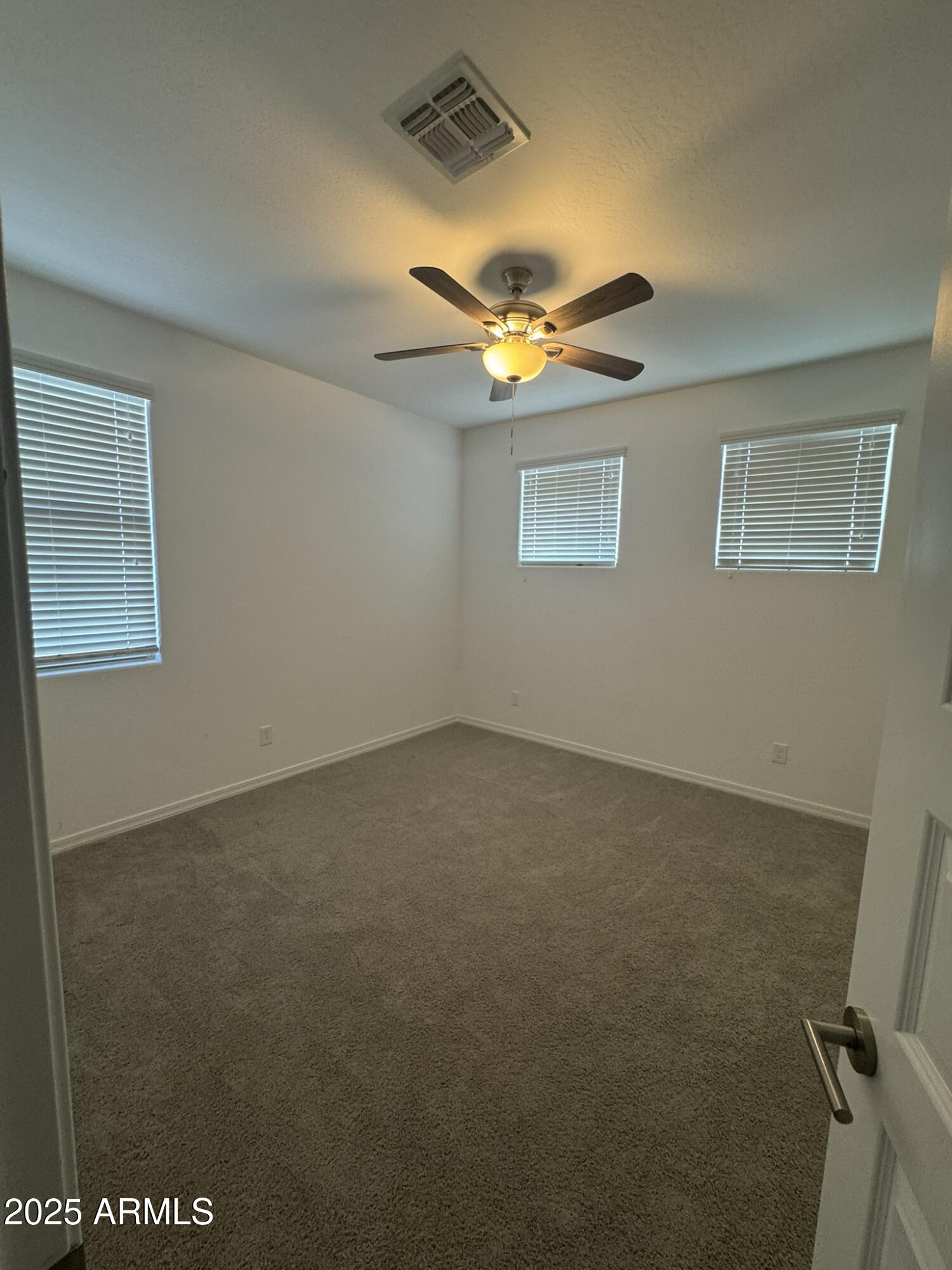 22742 East Domingo Road Queen Creek, AZ 85142 - Photo 14 of 23 an empty room with a chandelier fan and windows
