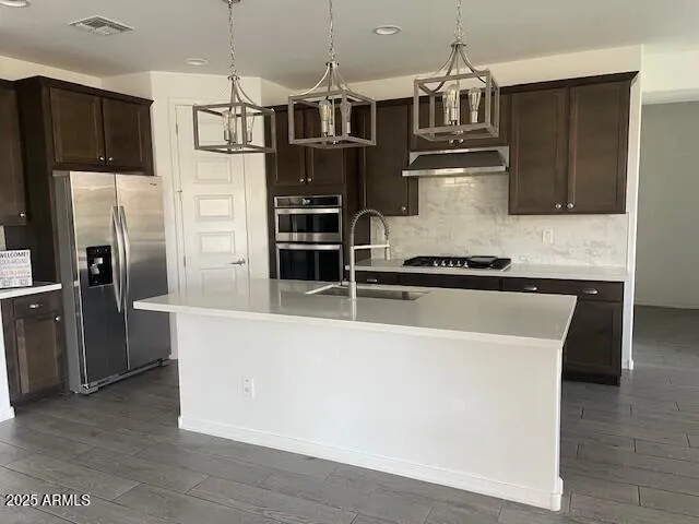 a large kitchen with stainless steel appliances a large counter top