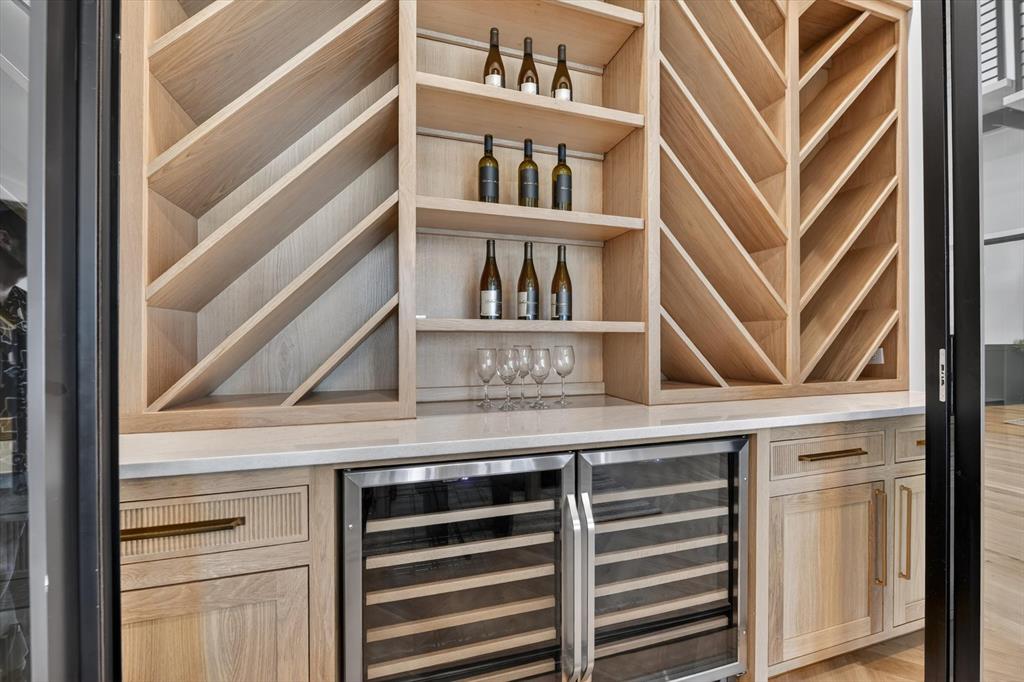 11028 Edgemere Road Dallas, TX 75230 - Photo 13 of 40 Built-in light wood cabinetry featuring open shelving and specialized bottle storage