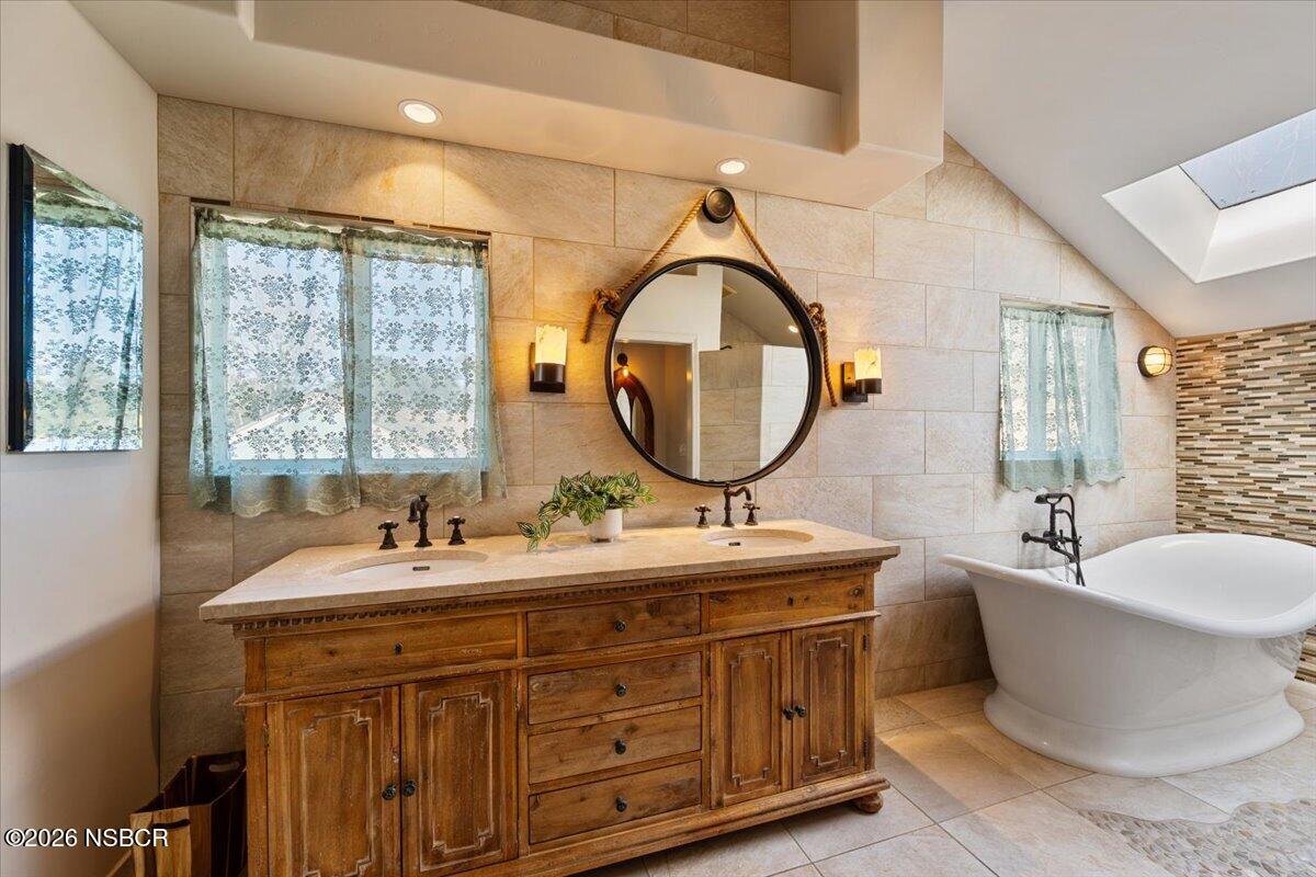 892 Onstott Road Lompoc, CA 93436 - Photo 18 of 40 a bathroom with a double vanity sink a mirror and a bathtub