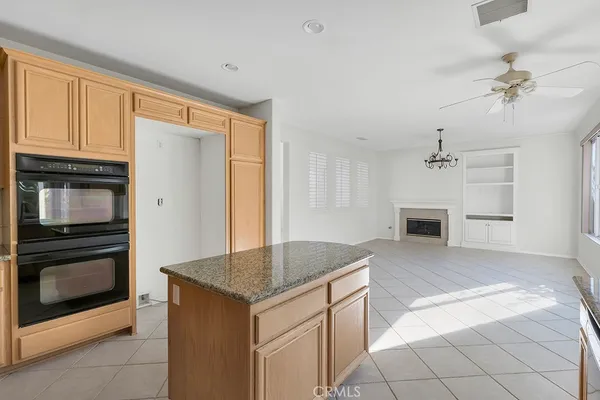 a kitchen with granite countertop a stove top oven and cabinets