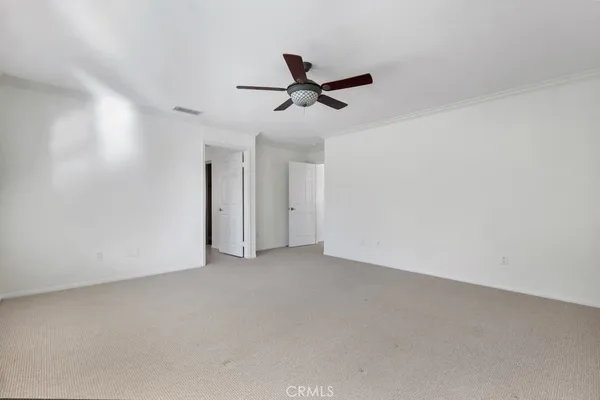 an empty room with a ceiling fan and window