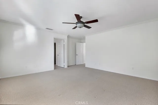 an empty room with a ceiling fan and window