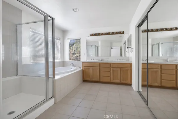 a bathroom with a tub sink shower and mirror