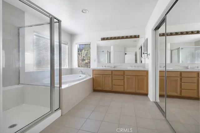 a bathroom with a tub sink shower and mirror