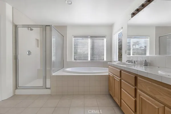 a spacious bathroom with a granite countertop tub sink shower and a mirror