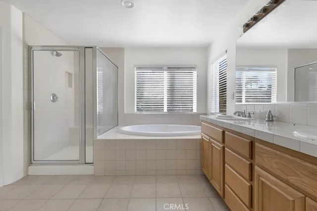 a spacious bathroom with a granite countertop tub sink shower and a mirror