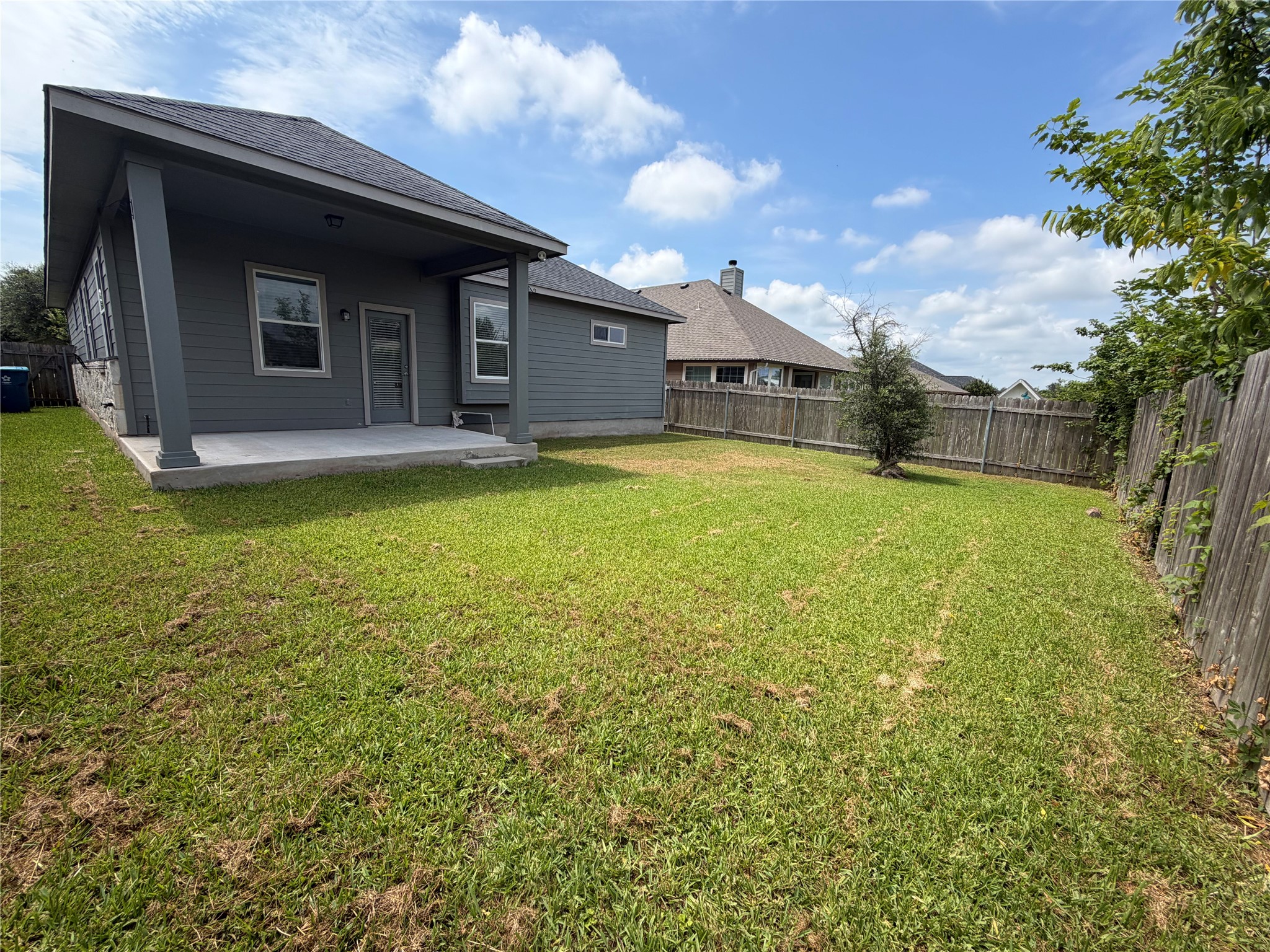 419 Gettysburg Loop Elgin, TX 78621 - Photo 18 of 21 A spacious yard extends beyond a covered patio, perfect for outdoor enjoyment.