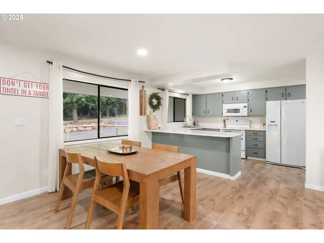 a kitchen with kitchen island a dining table and chairs