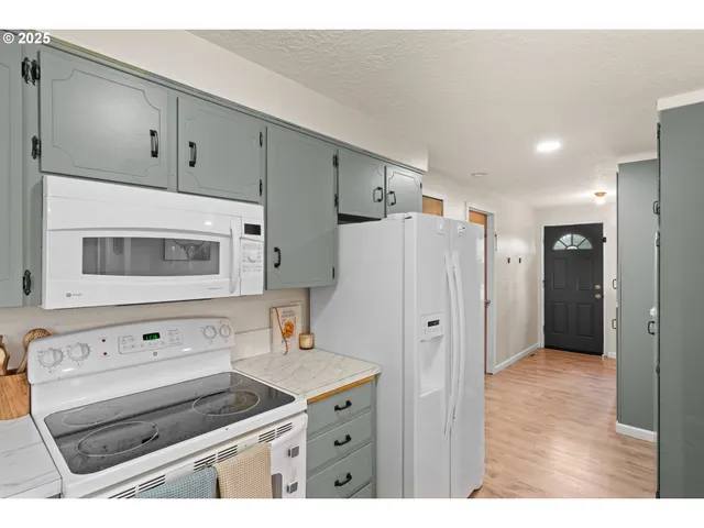 a kitchen with stainless steel appliances a stove a refrigerator and cabinets