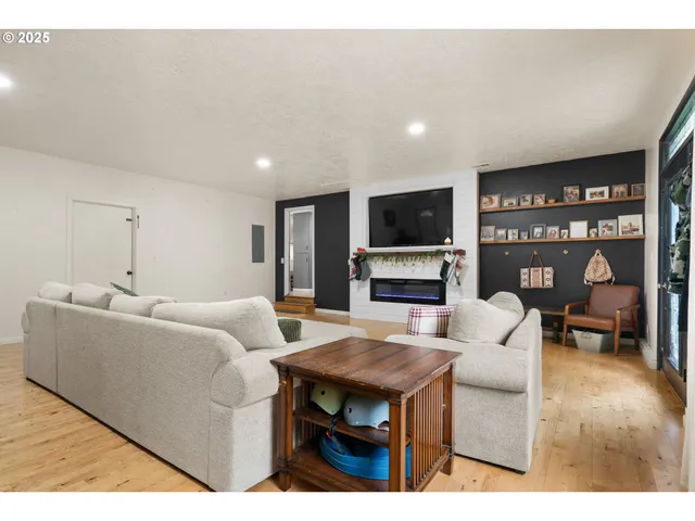 a living room with furniture a flat screen tv and a fireplace