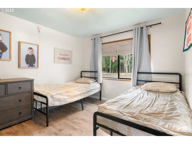 a bedroom with a bed window and a table in it