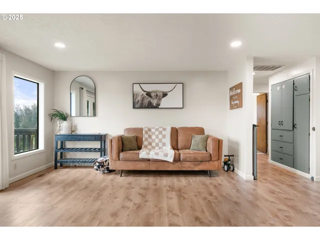 a living room with furniture and a wooden floor