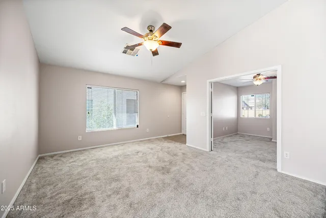 an empty room with windows and fan