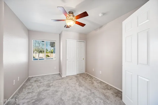 an empty room with closet and fan