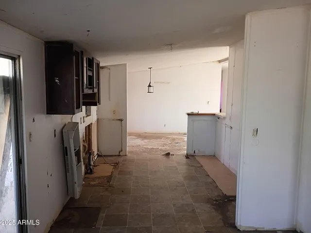 an empty room with windows and cabinet