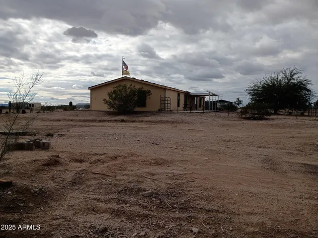 a view of a dry yard with wooden fence