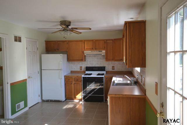 104 Ruel Avenue Hanover, PA 17331 - Photo 3 of 11 a kitchen with a refrigerator a stove top oven a sink and cabinets