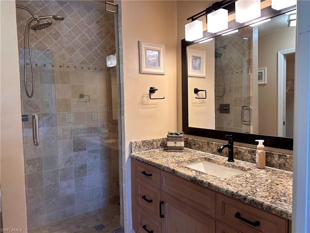 321 Robin Hood Circle, Unit 201 Naples, FL 34104 - Photo 12 of 28 a bathroom with a granite countertop shower sink and mirror