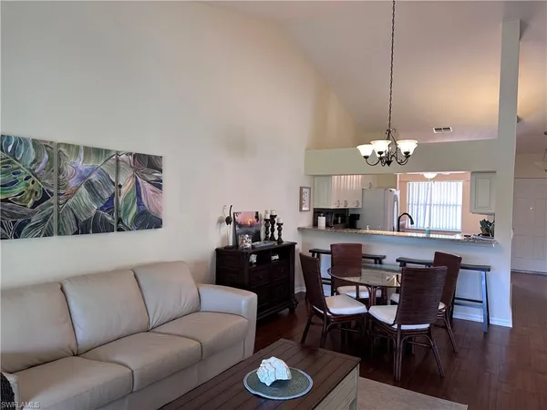 a living room with furniture a chandelier and a dining table