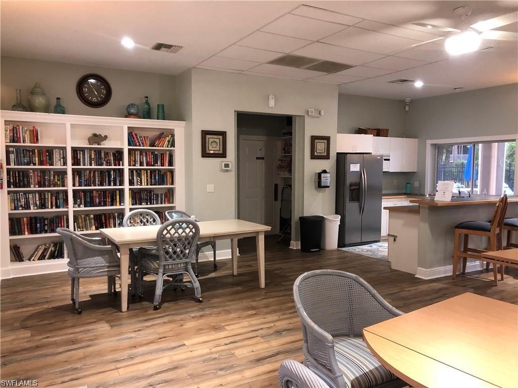 321 Robin Hood Circle, Unit 201 Naples, FL 34104 - Photo 27 of 28 a view of a dining room with furniture and wooden floor