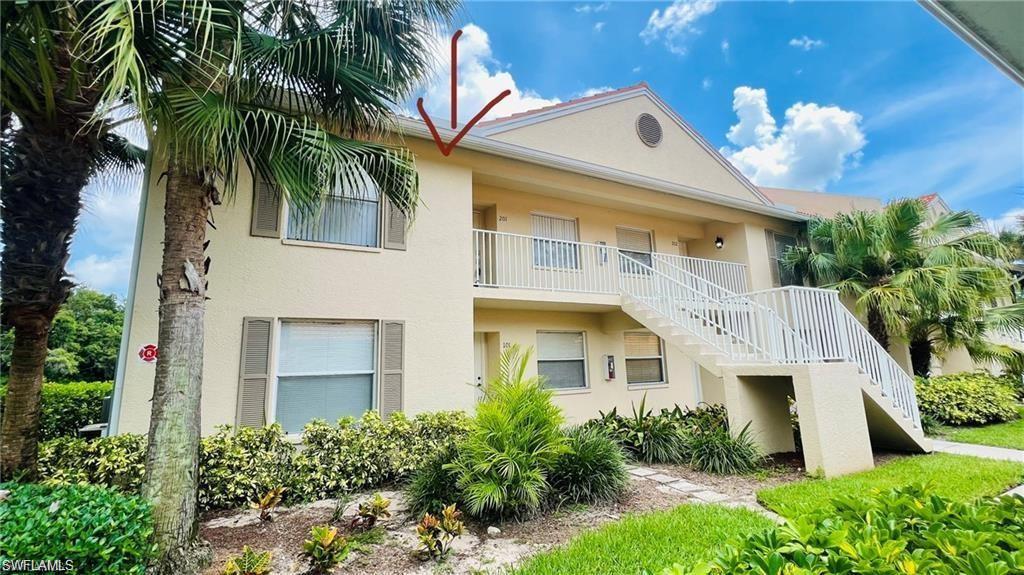321 Robin Hood Circle, Unit 201 Naples, FL 34104 - Photo 3 of 28 a front view of a house with a yard