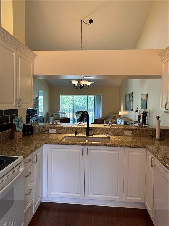 321 Robin Hood Circle, Unit 201 Naples, FL 34104 - Photo 6 of 28 a kitchen with kitchen island granite countertop a sink and cabinets