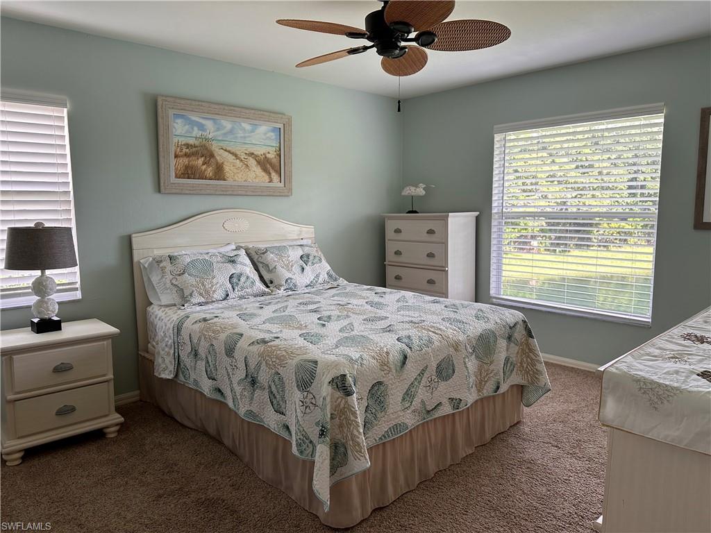 321 Robin Hood Circle, Unit 201 Naples, FL 34104 - Photo 10 of 28 a bedroom with a bed and a chandelier