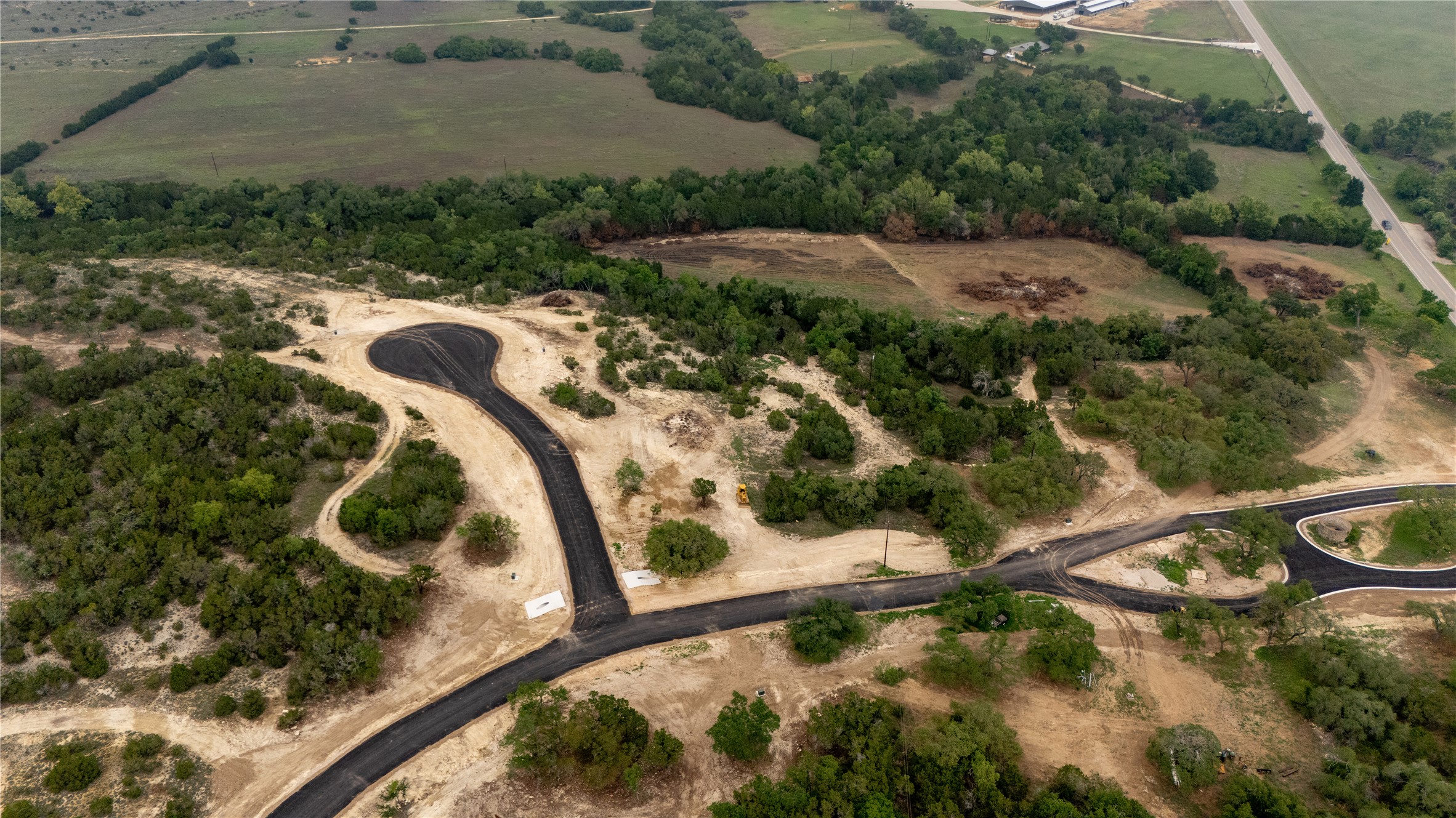 Lot 26 Ranch Road 165 Dripping Springs, TX 78620 - Photo 5 of 13 Aerial property perspective featuring newly paved roads and cul-de-sacs, surrounded by natural foliage and cleared land