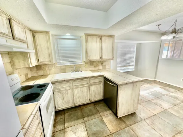 a kitchen with a sink stove and cabinets