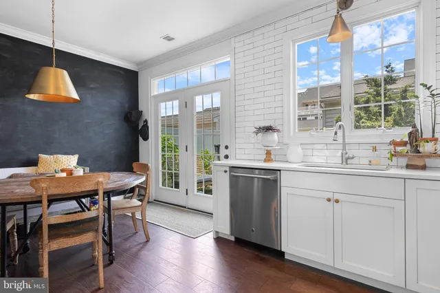 a kitchen with a table chairs and wooden floor