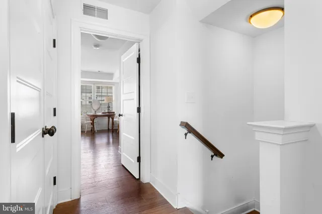 a view of a hallway with wooden floor and staircase