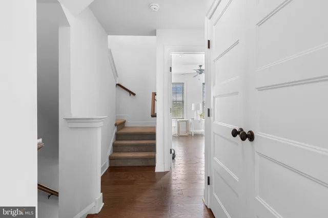 a view of a hallway with wooden floor and staircase