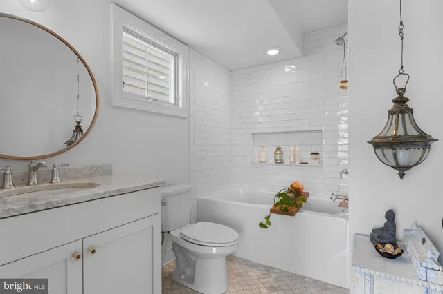 a bathroom with a granite countertop toilet sink and mirror
