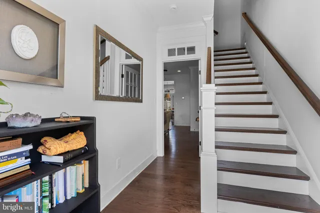 a view of a livingroom with wooden floor and stairs